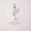 A silver-hooked butterfly pendant keychain set featuring pink iridescent wings and purple beads.