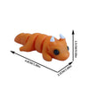 An orange, coiled cartoon animal figurine with white tips, shown from the side.