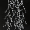 A cascade of clear crystal acrylic pendant ornaments hanging against a dark background.