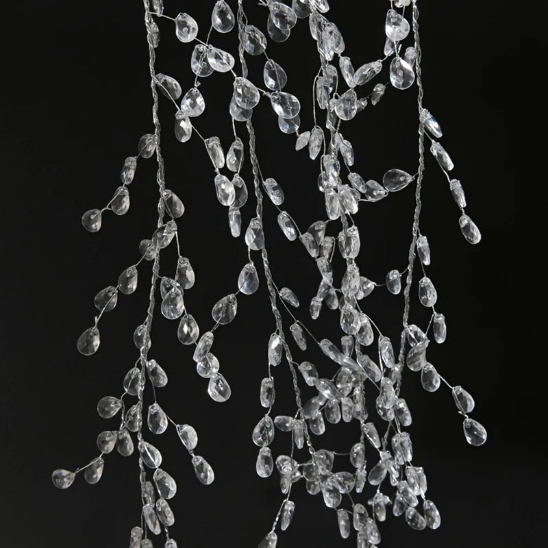 A cascade of clear crystal acrylic pendant ornaments hanging against a dark background.