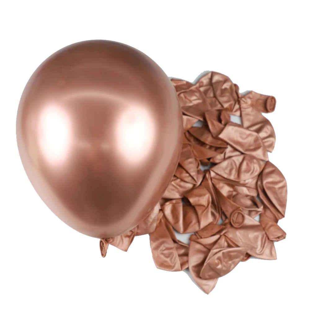 A single, shiny rose gold latex balloon is shown next to a pile of crumpled rose gold metallic foil balloons.