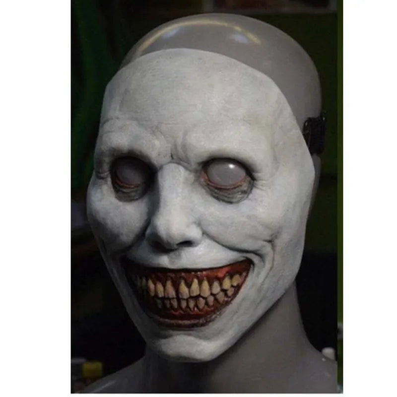 A white latex mask resembling a ghostly face with exaggerated features and a headscarf.