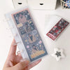 A hand holds a vertical transparent photocards holder displaying several photos with pink and purple accents.
