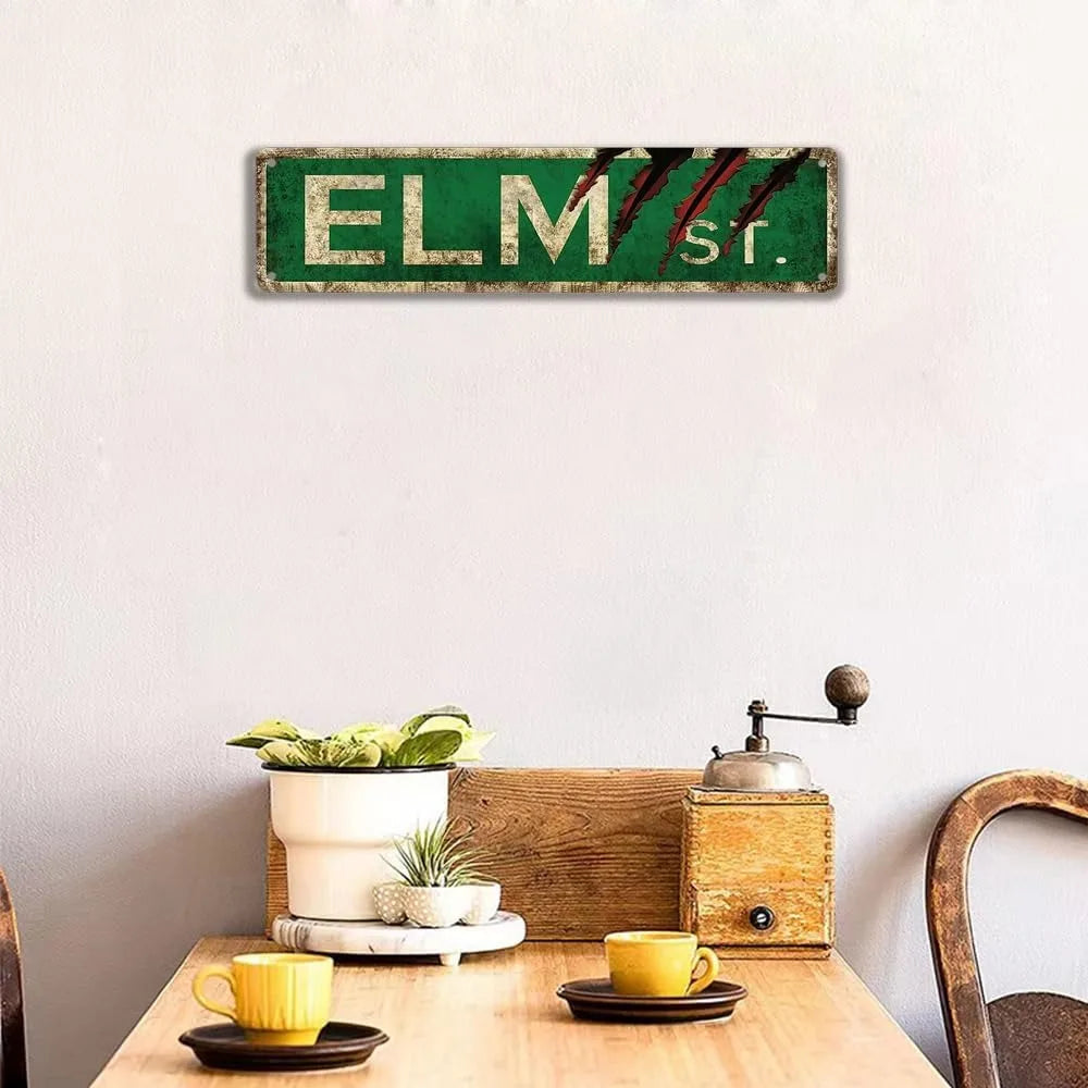 Vintage metal tin sign with green background and red stripes spelling out ELM St.