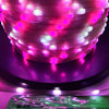 Close-up of pink and white addressable LED string lights illuminating a purple surface.