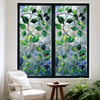 A window featuring a green leaf privacy film with intricate patterns of leaves and branches.