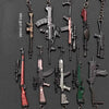 A collection of realistic miniature gun models on keychains, featuring various firearms in different colors and styles.