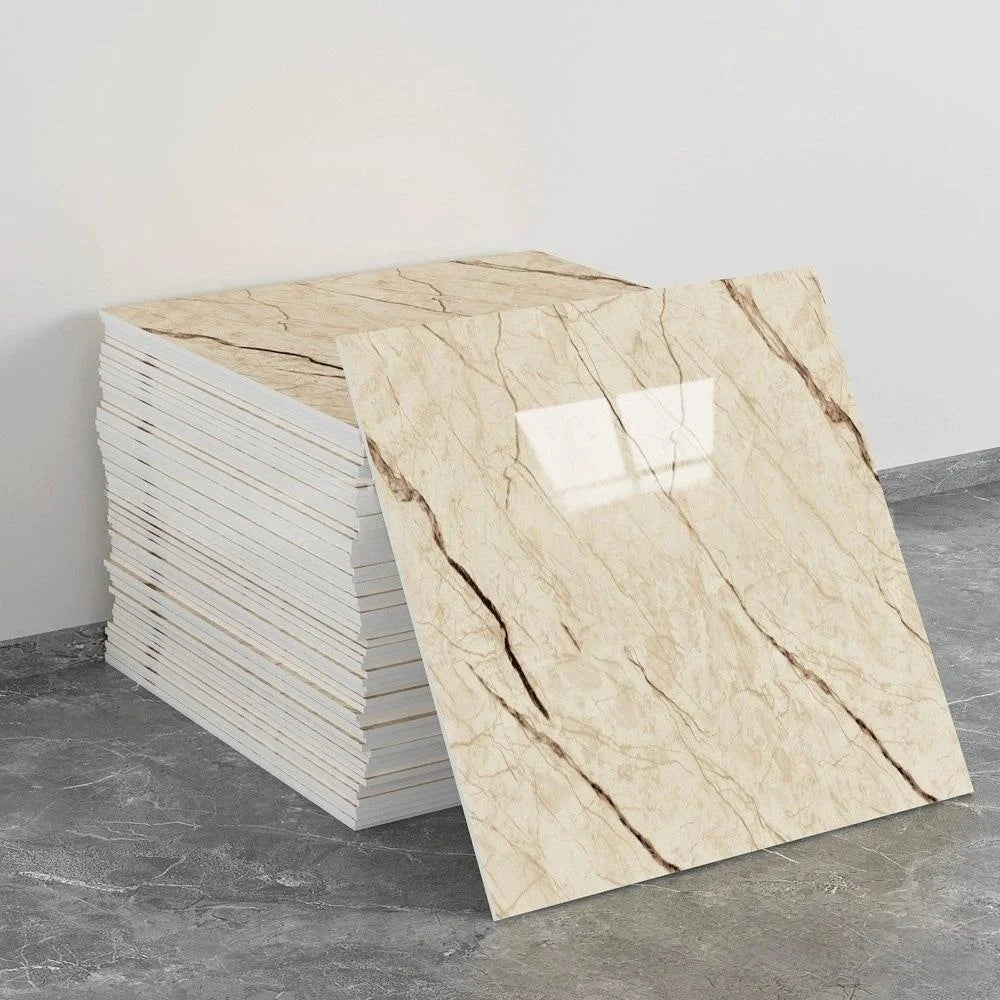 A stack of self-adhesive marble tile stickers showing a beige and brown veined pattern on a gray floor.