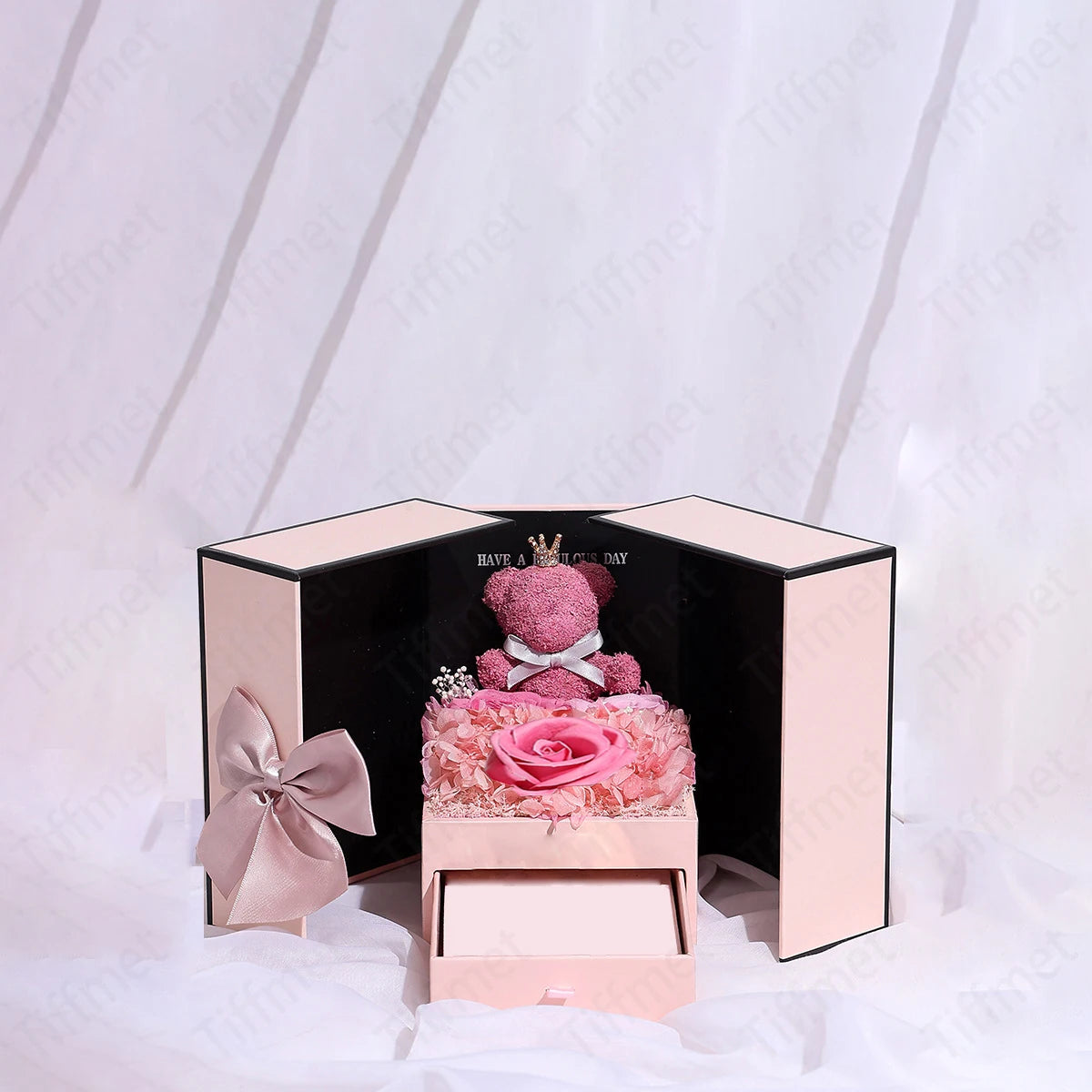 A pink gift box containing a cute bear rose pendant necklace.