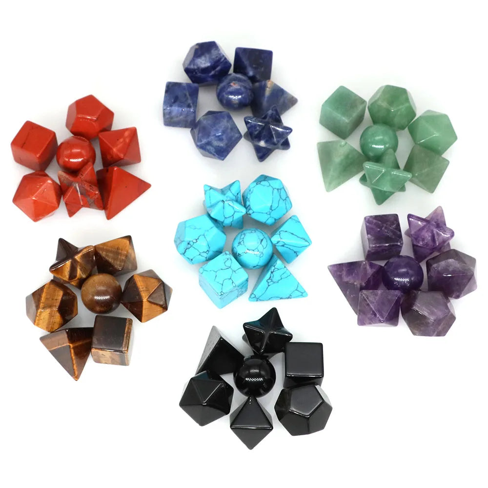 A collection of seven colored platonic geometry crystals including red, blue, green, and purple stones.