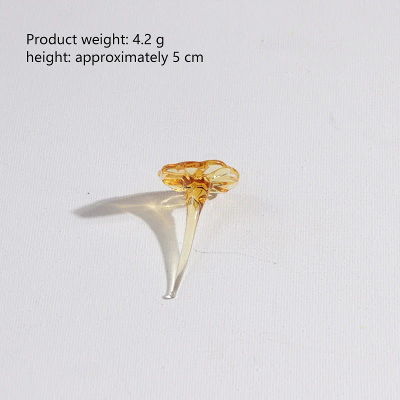A small, translucent glass flower with a delicate stem and petals, used for home decor.