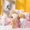 A collection of mini plush teddy bear keychains in various shades of beige and white displayed on a pink box.