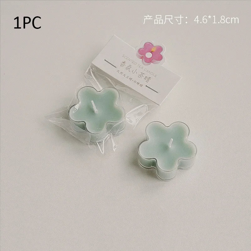 A single light green flower shaped tea light candle is shown in clear packaging.