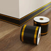 Rolls of black and gold self-adhesive PVC skirting board trim for flooring