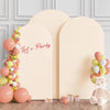 A light pink arch stand backdrop decorated with balloons and a 'Let's Party' sign for an event.