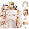 A set of boho rainbow cake toppers featuring a teddy bear, pink balls, and gold accents.
