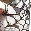Close-up of Halloween spider web window decals showing colorful patterns on both sides