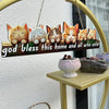 A rustic wooden inspirational hanging sign featuring several cat figurines on a light wood plank.
