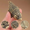 A close-up of a detailed copper alligator desk decor figurine with textured scales.