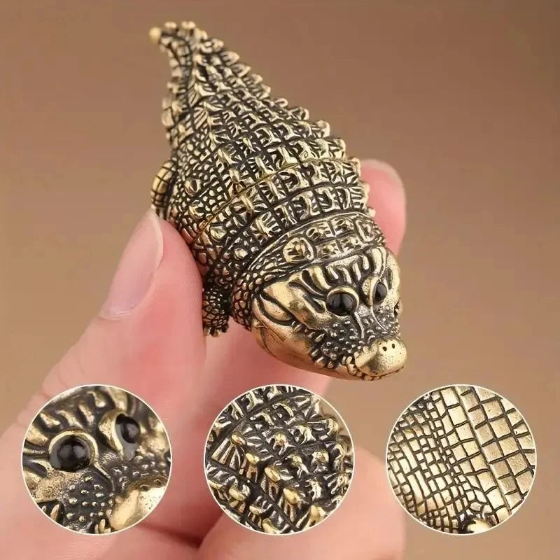 A close-up of a detailed copper alligator desk decor figurine with textured scales.