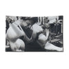 A black and white photograph of a muscular man exercising in a gym setting.