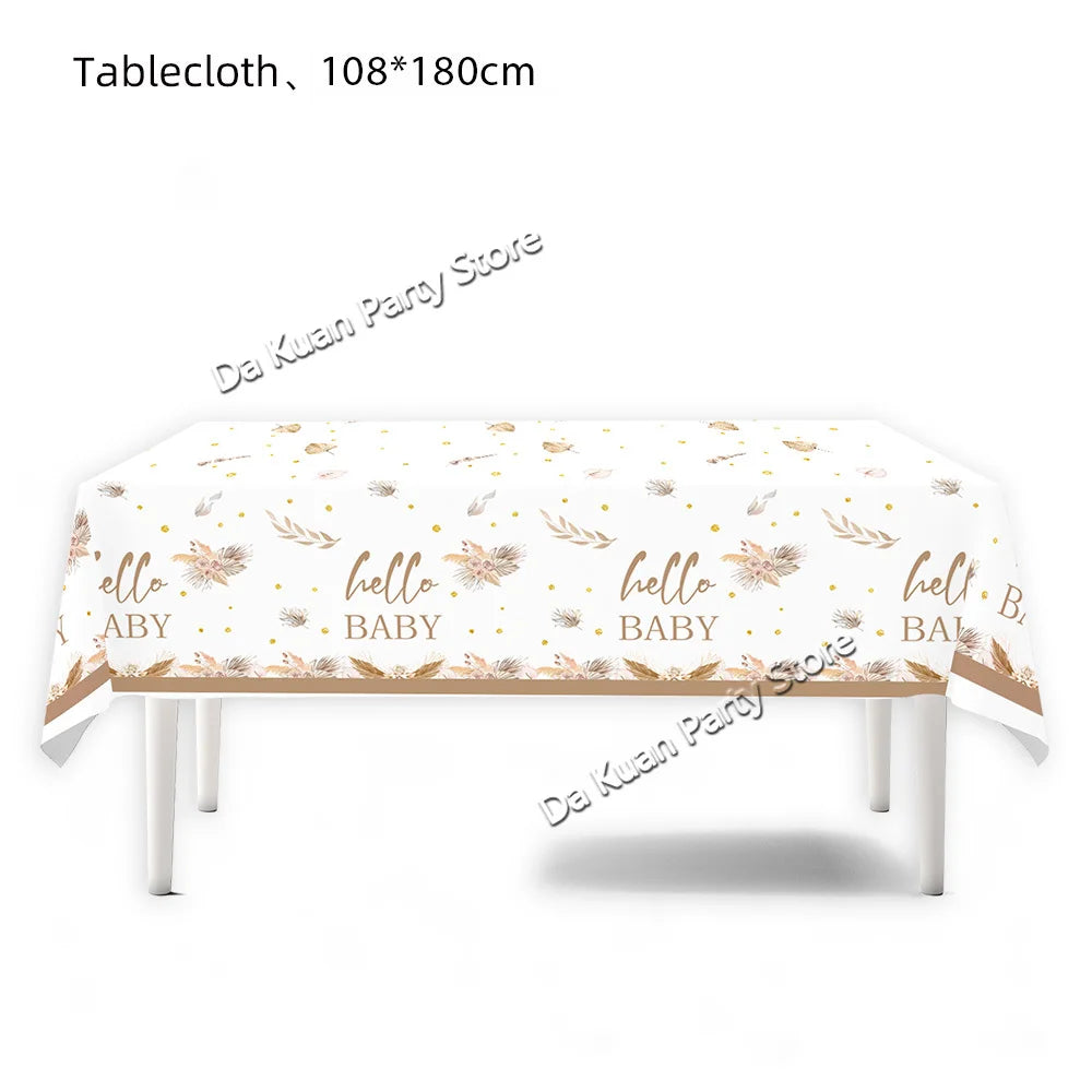 A white tablecloth decorated with gold floral patterns and 'hello baby' text for a gender reveal or baby shower.