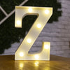 A glowing warm white LED alphabet letter light shaped like the letter Z resting on a wooden surface.