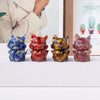 Four natural fox crystal sculptures in various colors and textures displayed on a white surface.