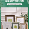 A set of four handcrafted wooden photo frames with white mats and dark wood borders displayed on a wooden surface.