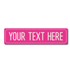 A pink rectangular metal street sign with the text YOUR TEXT HERE.