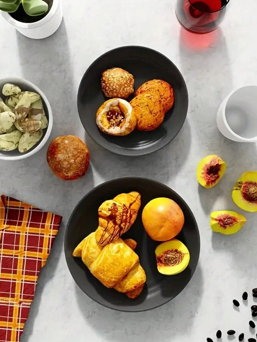 A dark plate holds golden pastries and fruit on a light gray surface.