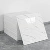 A stack of white marble tile stickers on a gray floor.