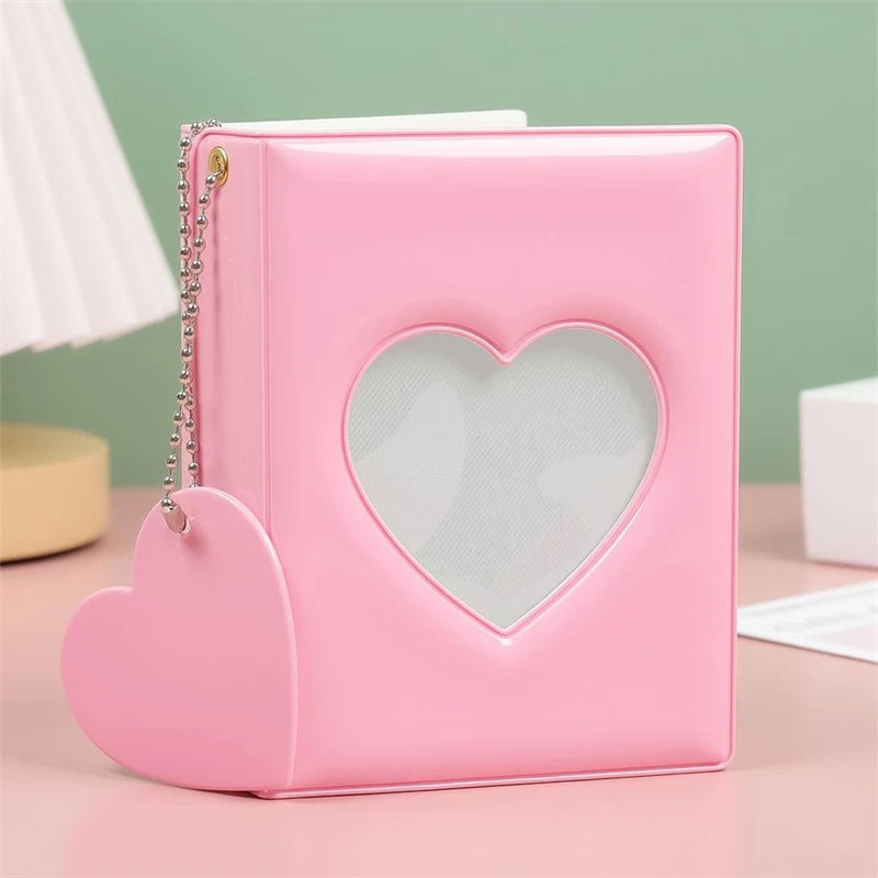 A pink candy heart window photocard album with a heart-shaped cutout and a silver chain.