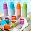 A collection of colorful disposable plastic shot cups in various shades including purple, blue, orange, and green.