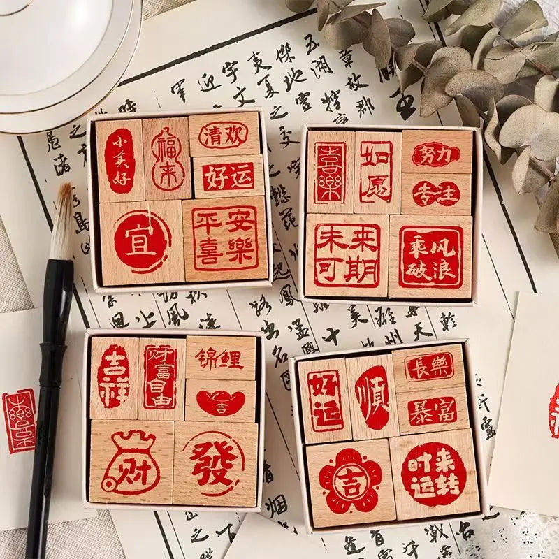 A set of six wooden Chinese character stamps arranged on a white background with calligraphy and foliage.