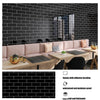 A modern living room featuring a pink sofa and a dark tiled wall with a rectangular marble pattern self-adhesive backsplash p