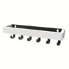 A white wooden floating shelf with black supports and hooks.