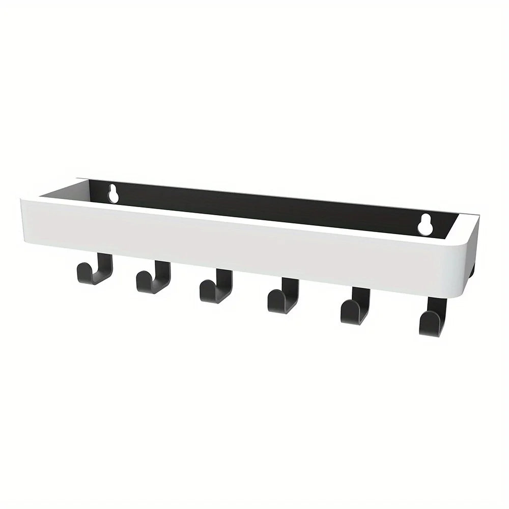 A white wooden floating shelf with black supports and hooks.
