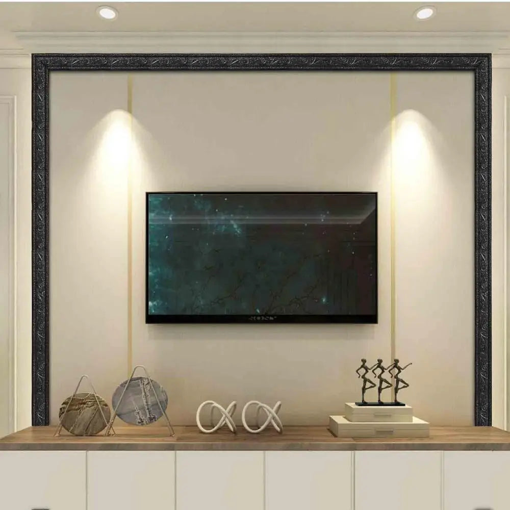 A modern living room wall featuring a large television framed by dark trim strips and illuminated by vertical lights.