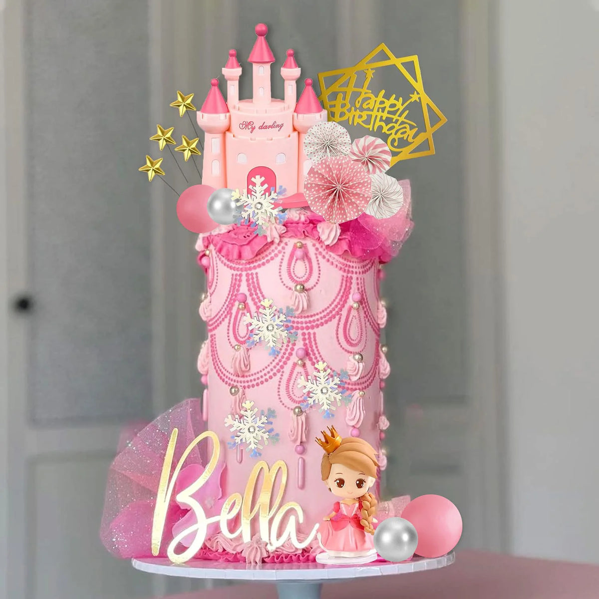 A pink princess castle cake topper set featuring a castle, flowers, and a golden star shape for a birthday celebration.