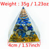 A pyramid-shaped crystal display featuring blue and yellow stones with a copper coil inside.