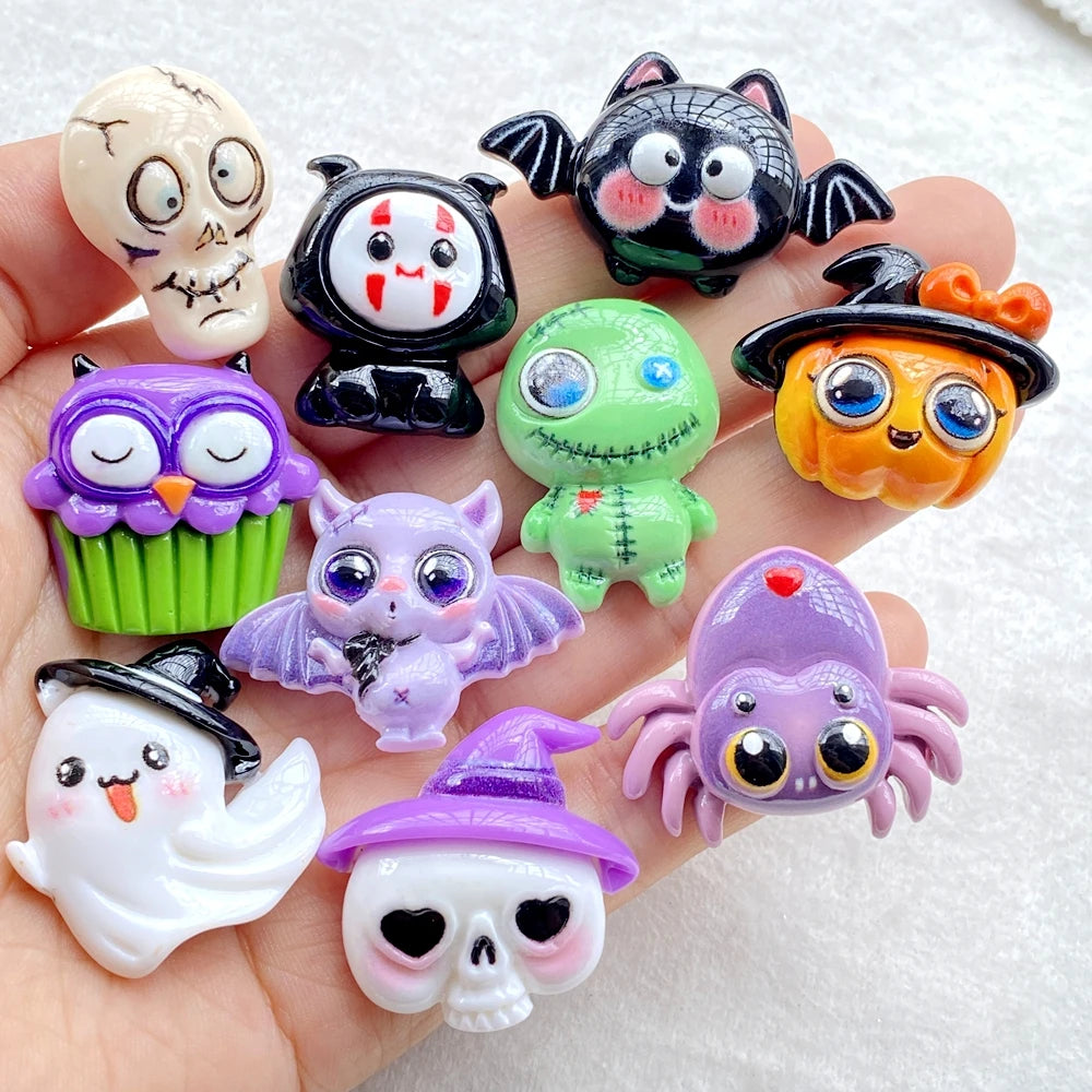 A collection of colorful Halloween resin charms featuring skulls, bats, cats, and other spooky creatures.