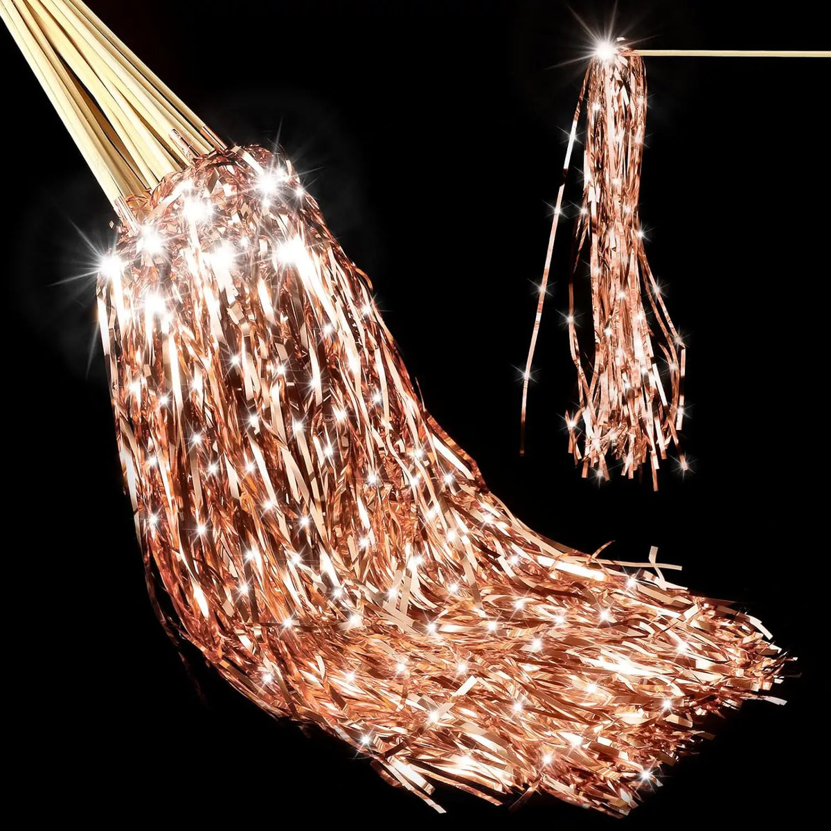 A close-up of lighted tinsel wedding wands with LED glow hanging against a black background.