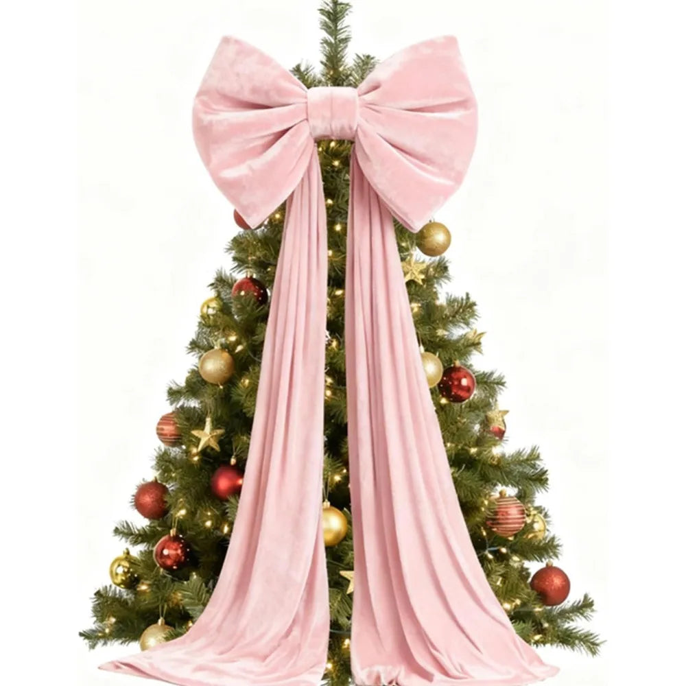 A festive Christmas tree decorated with gold and red ornaments and a large pink velvet bow with long draping tails.
