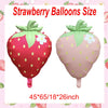 Two pink strawberry foil balloons showing the size 45x65x18x26 inches.