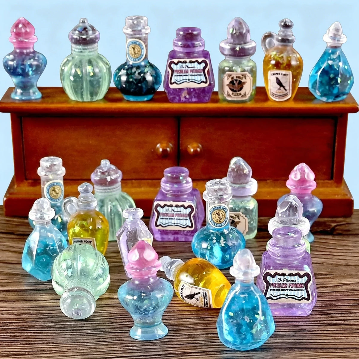 A collection of miniature resin magic potion bottles in various colors and shapes displayed on a wooden surface.