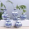 Blue and white ceramic flower vase with intricate floral patterns displayed on a white surface.