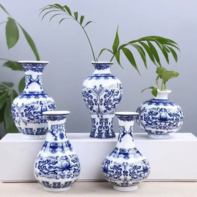 Blue and white ceramic flower vase with intricate floral patterns displayed on a white surface.