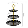 A three-tier black and gold plastic dessert stand with scalloped plates.