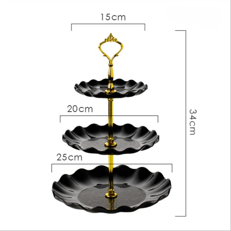 A three-tier black and gold plastic dessert stand with scalloped plates.